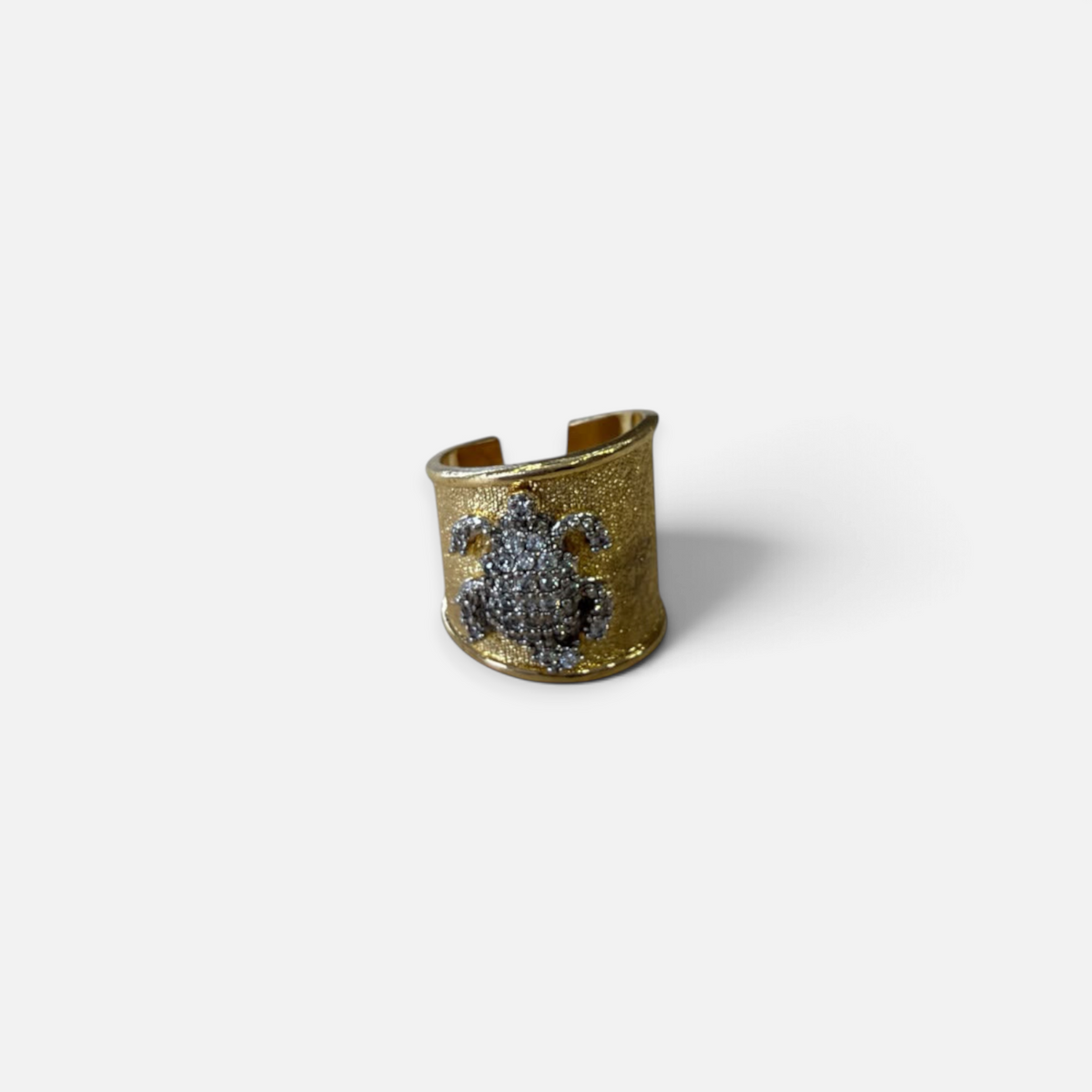 Jakris gold plated ear cuff featuring a textured surface and a sparkling zircon stone turtle design.