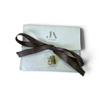 Jakris gold-plated ear cuff with a textured surface and a sparkling zircon turtle figure, displayed on a branded pouch.