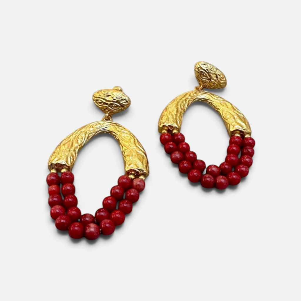Jakris Rossa statement earrings featuring textured 24k gold-plated bronze hoops with vibrant red coral bead strands.