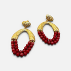 Jakris Rossa statement earrings featuring textured 24k gold-plated bronze hoops with vibrant red coral bead strands.