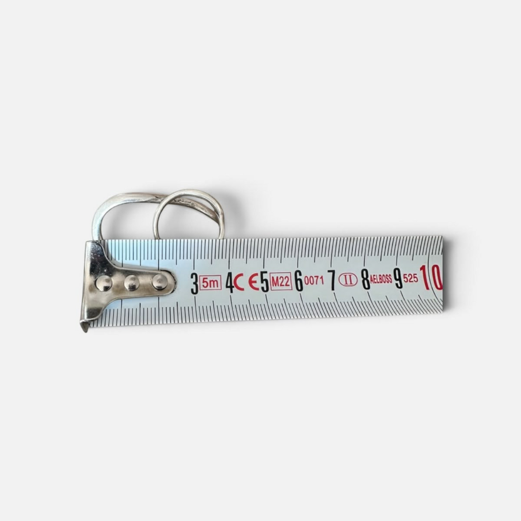 Jakris Reilly gold-plated two-finger ring resting on a metal measuring tape against a white background