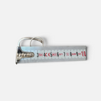 Jakris Reilly gold-plated two-finger ring resting on a metal measuring tape against a white background