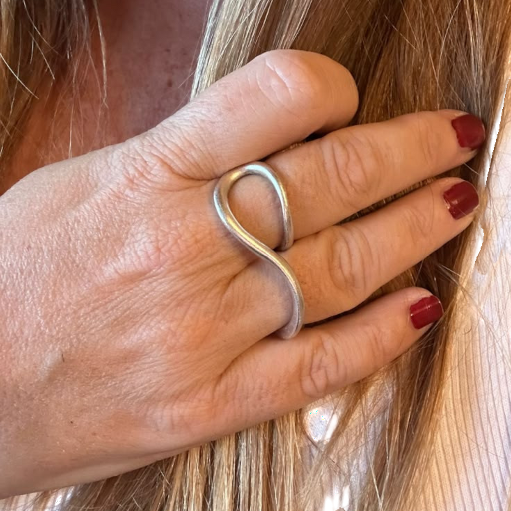 Jakris Reilly gold-plated two-finger ring with a minimalist curved design worn on a woman's hand
