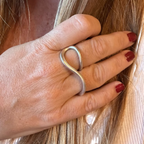 Jakris Reilly gold-plated two-finger ring with a minimalist curved design worn on a woman's hand