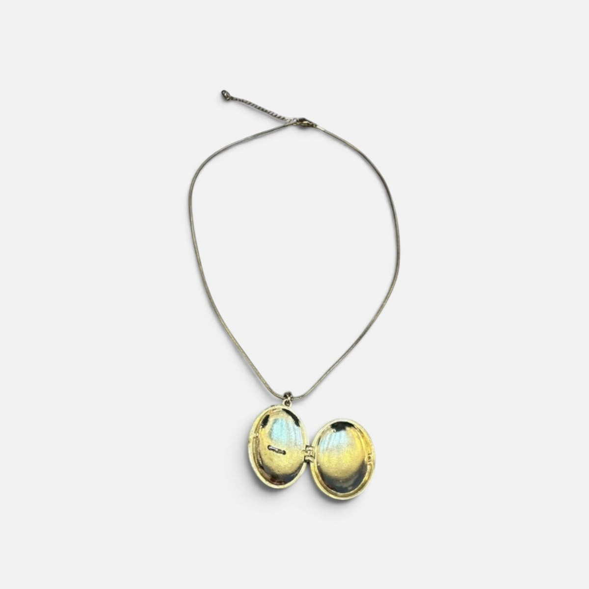 Jakris gold-plated oval locket necklace with an open design, featuring a delicate chain and symbolic phoenix motif.
