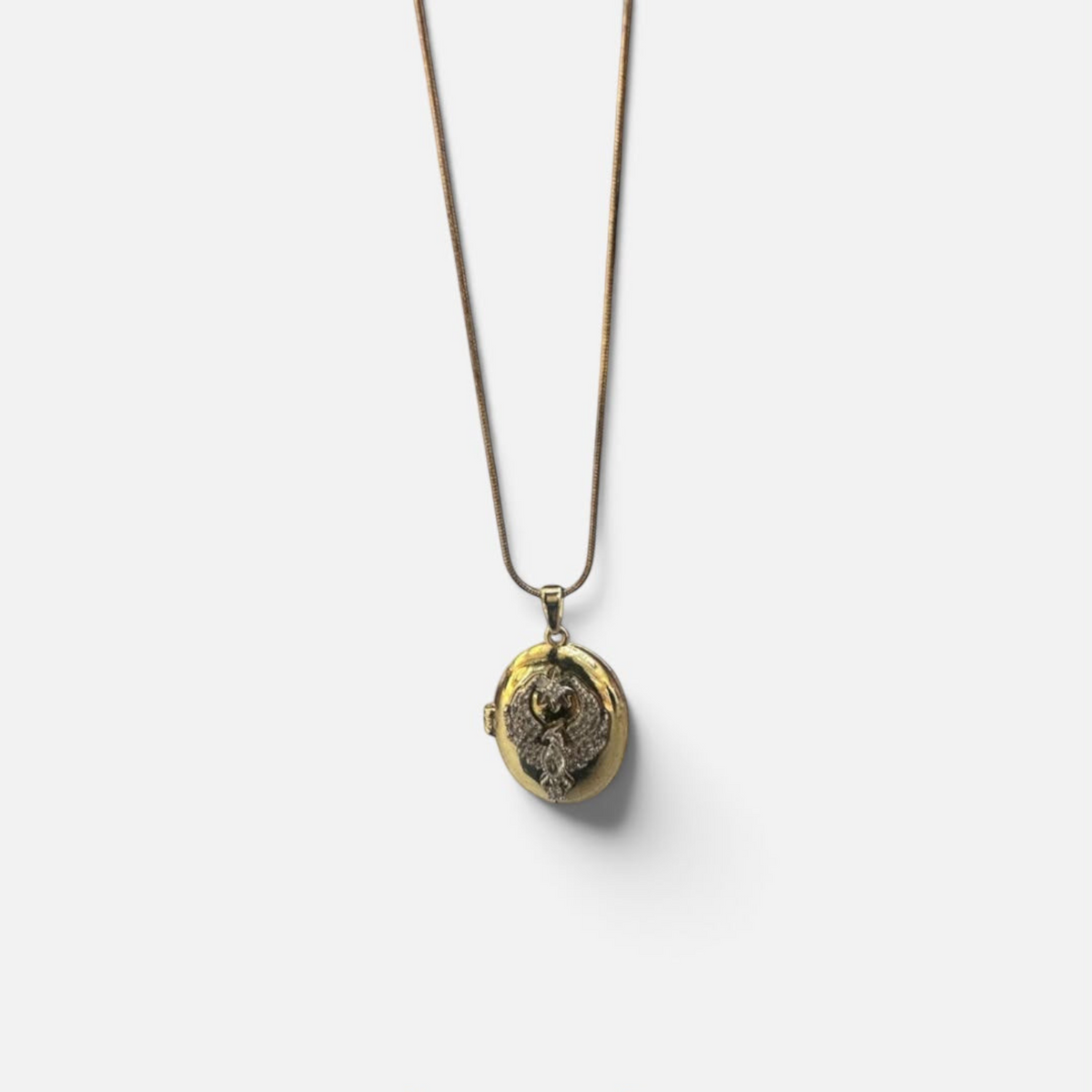 Jakris gold-plated oval locket necklace featuring a zircon-encrusted phoenix design on a delicate chain