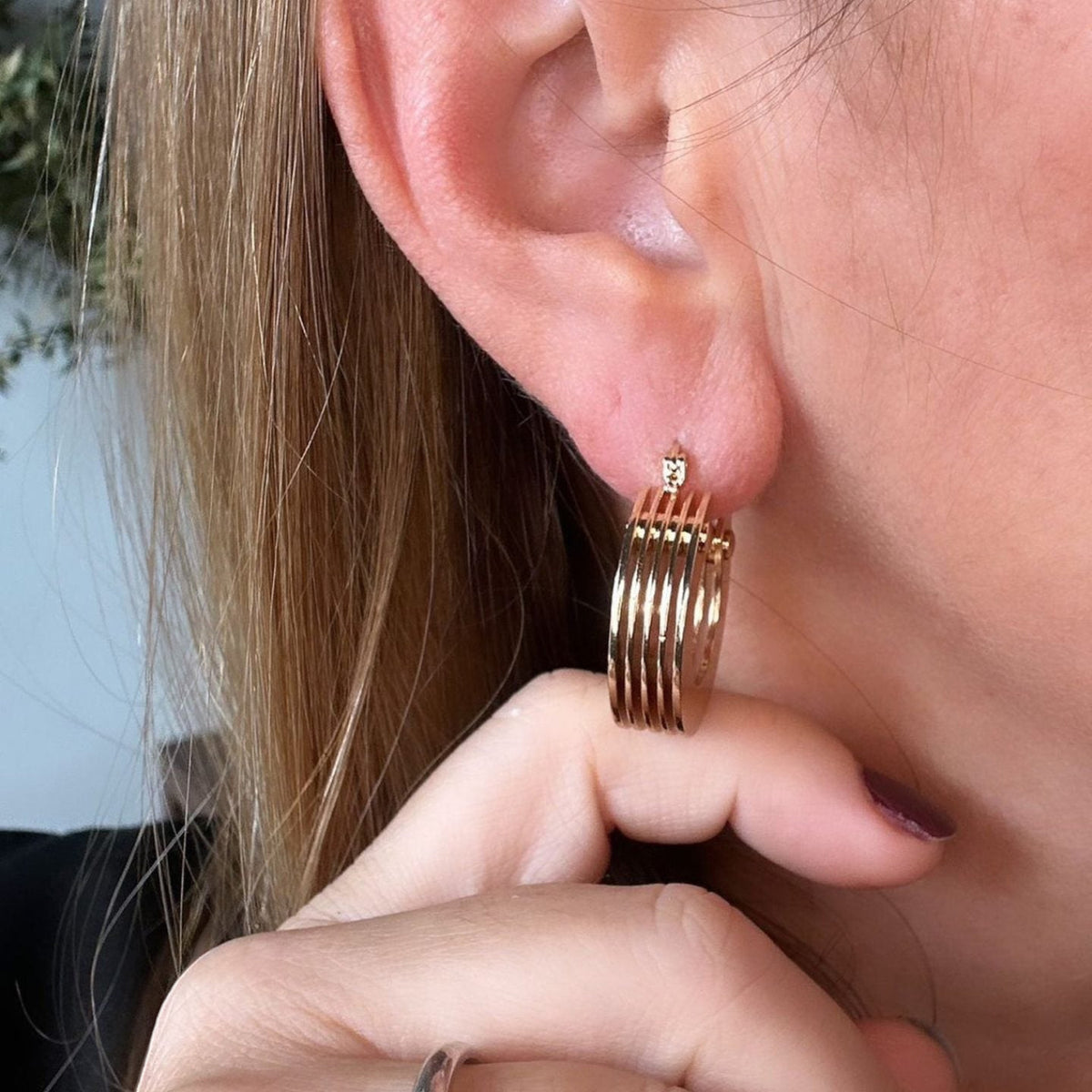 Jakris 5-layer small thick gold hoop earring worn on a woman's earlobe