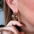 Jakris 5-layered small thick gold hoop earrings worn on a woman's ear