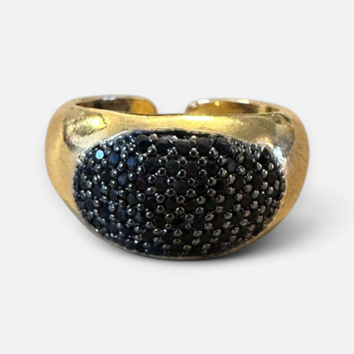 Jakris adjustable gold-tone ring featuring a wide band with a cluster of sparkling black zircon stones.