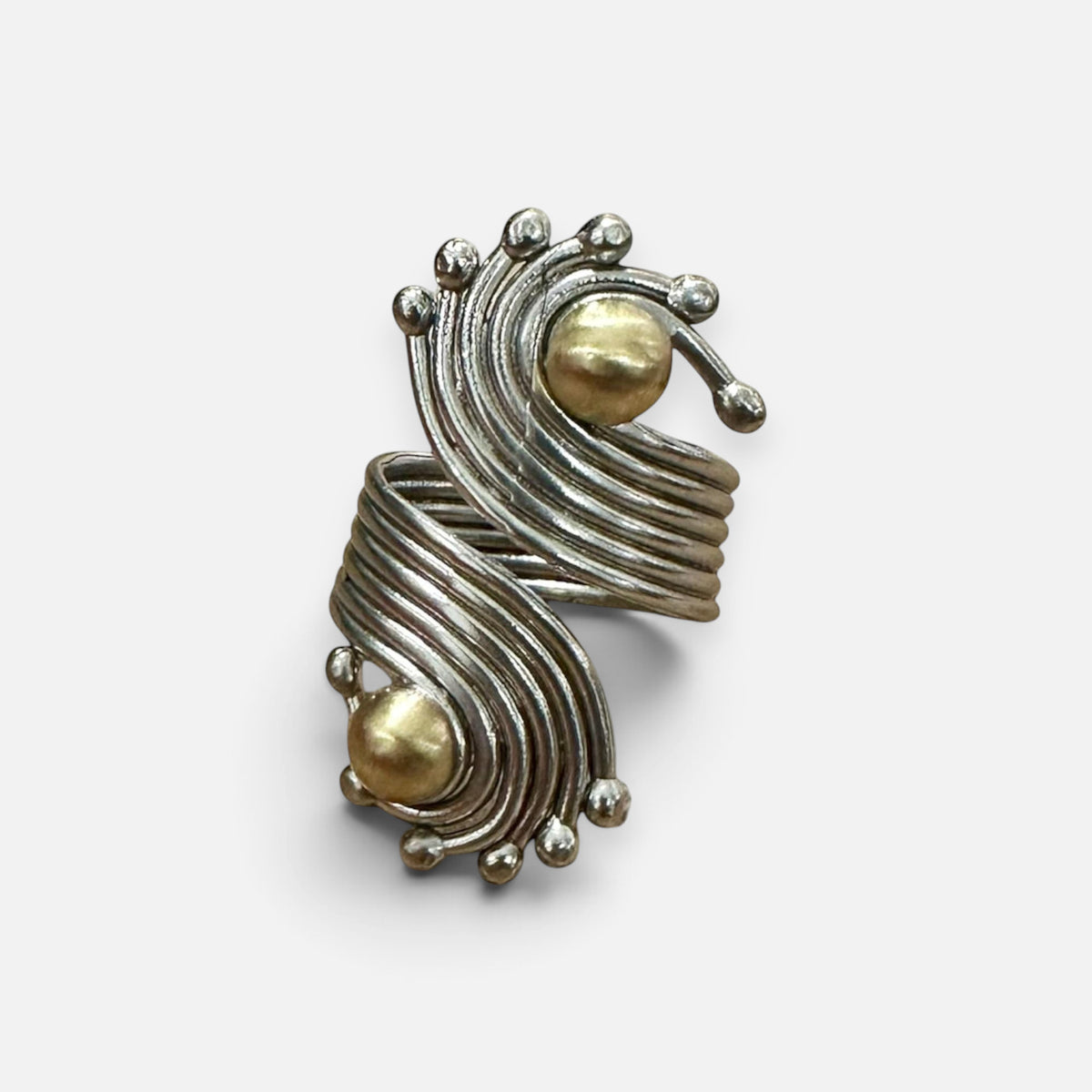 Jakris handmade adjustable ring in brass with white gold rhodium plating featuring swirling lines and gold spheres.