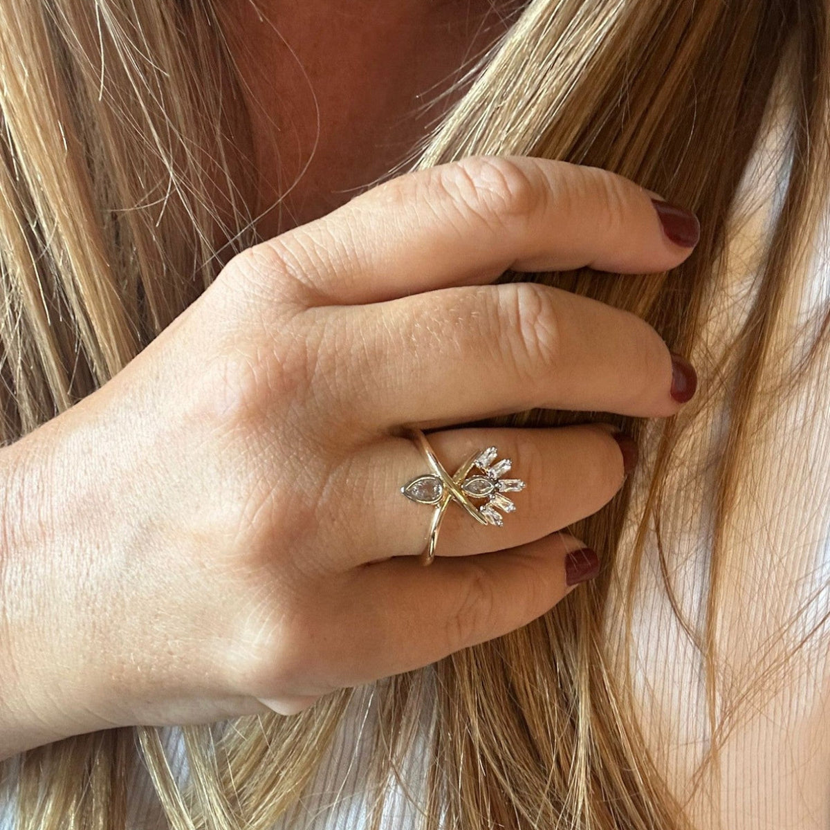 Jakris adjustable gold-tone ring featuring a unique abstract design with sparkling clear stones worn on a finger