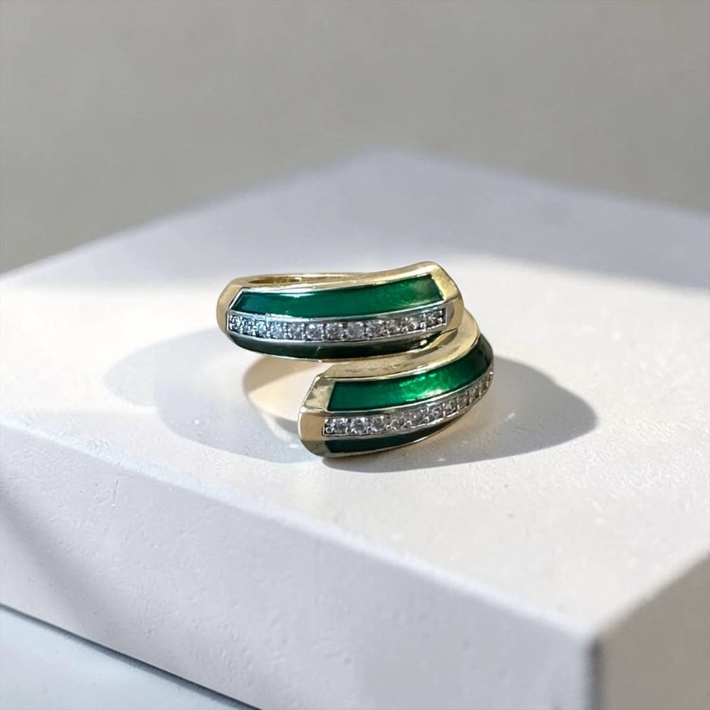 Jakris adjustable ring featuring a gold-tone band with green enamel inlay and a row of sparkling clear crystals.