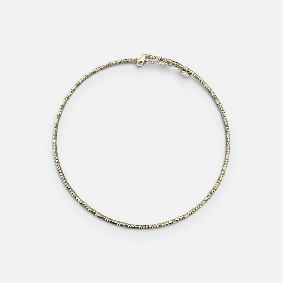 Jakris adjustable thin gold choker necklace with a delicate textured bead design on a white background