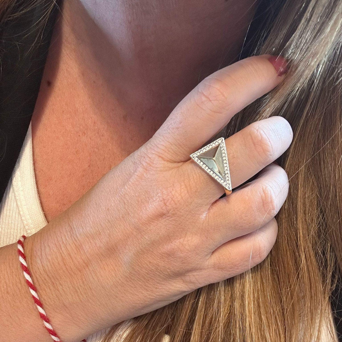 Jakris adjustable ring featuring a silver triangle pyramid design accented with sparkling crystals on a finger