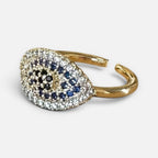 Jakris adjustable gold-tone ring featuring a teardrop-shaped evil eye motif with blue, black, and white zircon stones.