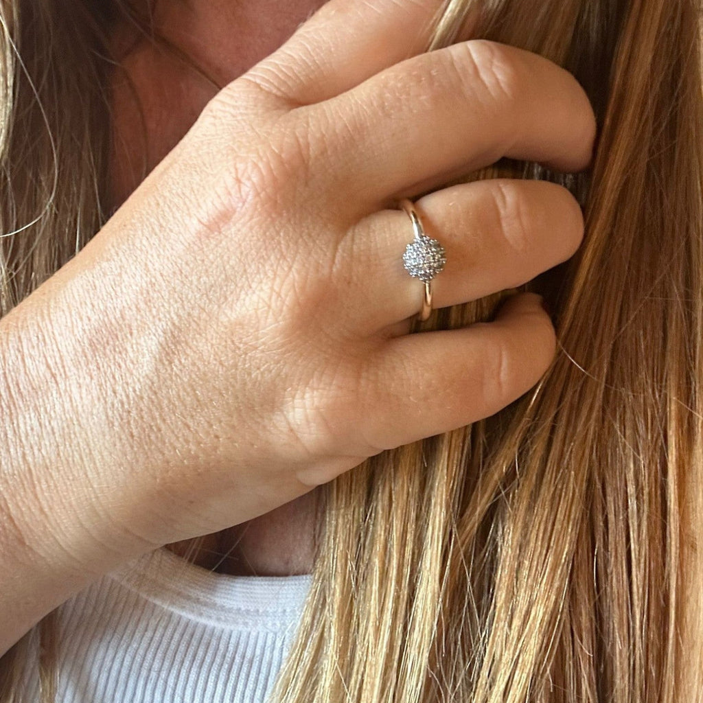 Jakris adjustable ring featuring a small round charm encrusted with sparkling zircon stones worn on a finger