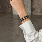 Jakris woven beaded bracelet featuring a black and gold lightning bolt pattern on a wrist