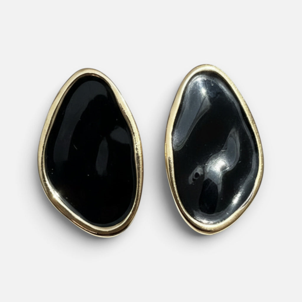 Jakris black oval earrings with a smooth glossy finish and gold-toned metal trim on a white background.