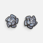 Jakris flower-shaped stud earrings featuring sparkling black and silver zircon stones on a white background