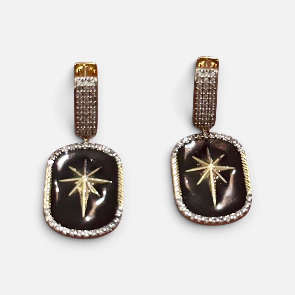Jakris black star dangle earrings featuring gold star accents and pave crystal borders on a gold-tone base