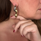 Jakris limited edition brass and white gold plated curved earrings worn on a model