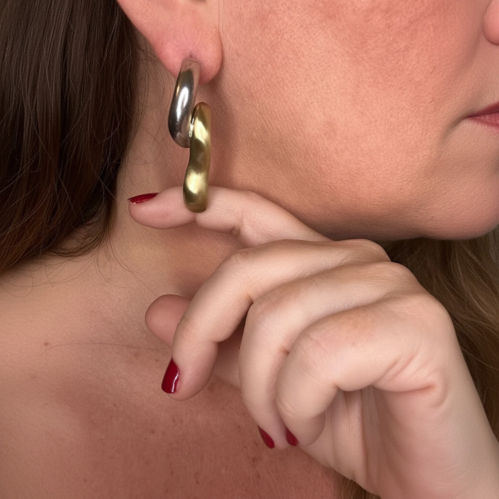 Jakris limited edition brass and white gold plated curved earrings worn on a model