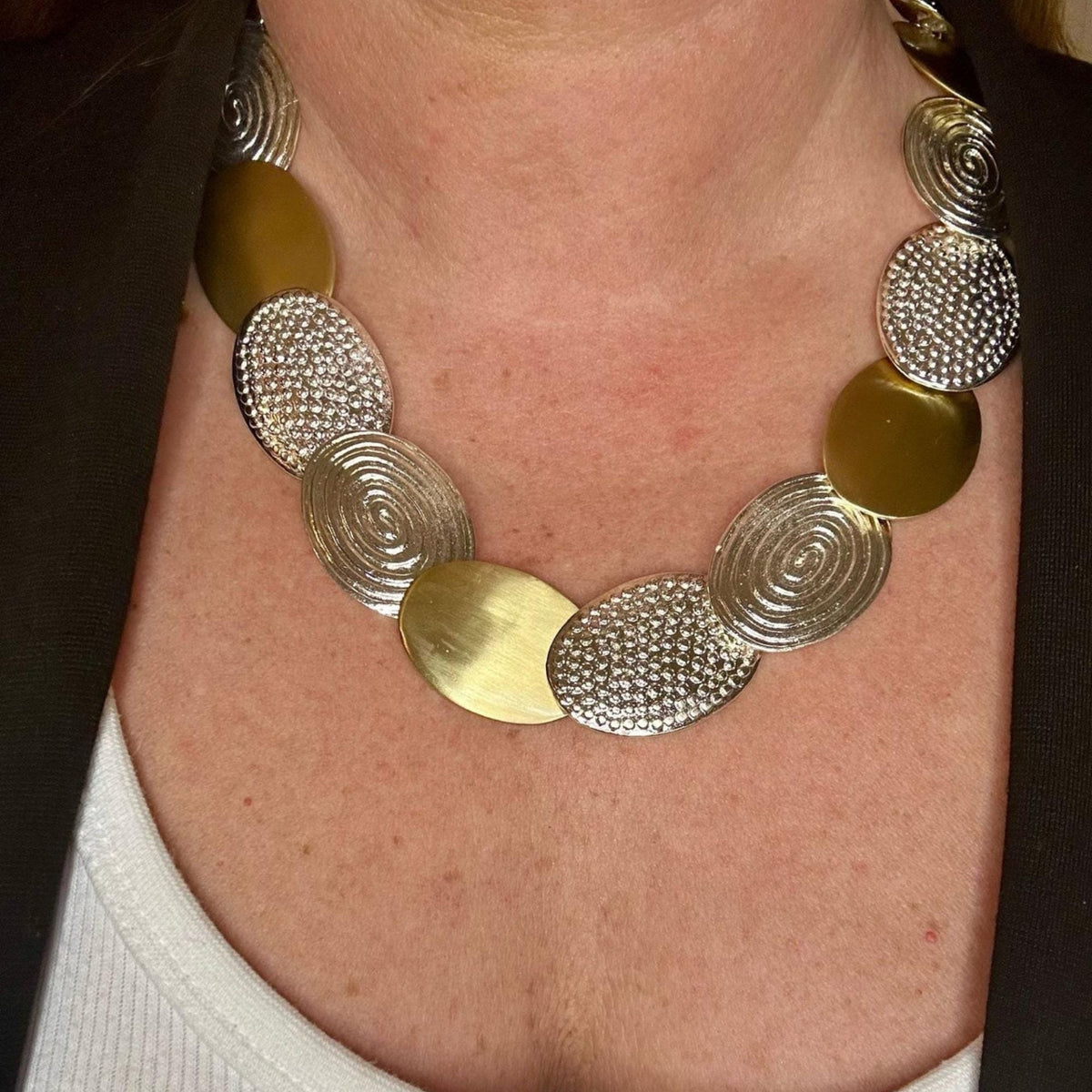Jakris handmade statement necklace featuring mixed brass and white gold plated textured oval discs on a model