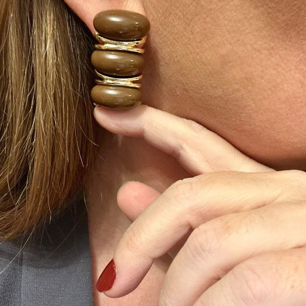 Jakris modern brown stacked hoop earrings with gold-tone accents worn on an earlobe