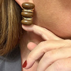 Jakris modern brown stacked hoop earrings with gold-tone accents worn on an earlobe