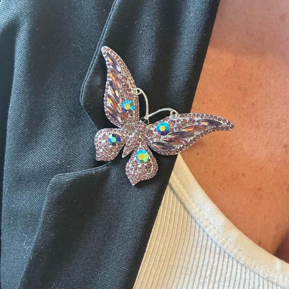 Jakris vintage butterfly brooch with sparkling purple crystals pinned to a black blazer