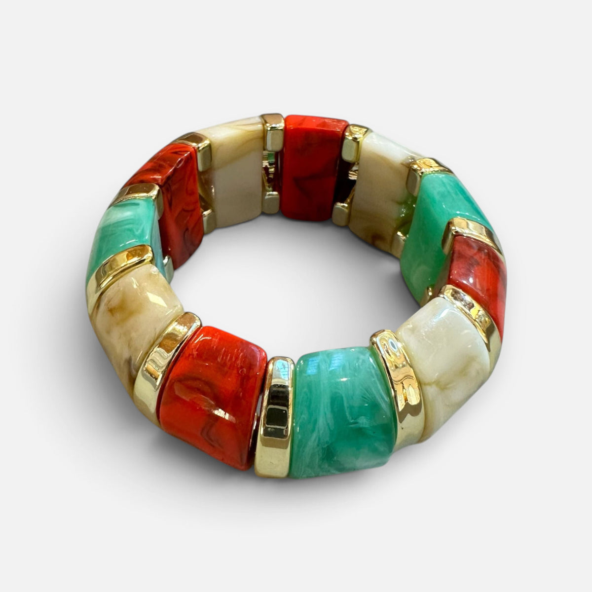 Jakris elastic bracelet featuring vibrant red, green, and cream color-block resin beads with gold-tone accents.
