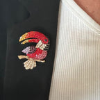 Jakris colorful toucan brooch featuring sparkling tropical bird design with vibrant crystals on a black blazer lapel
