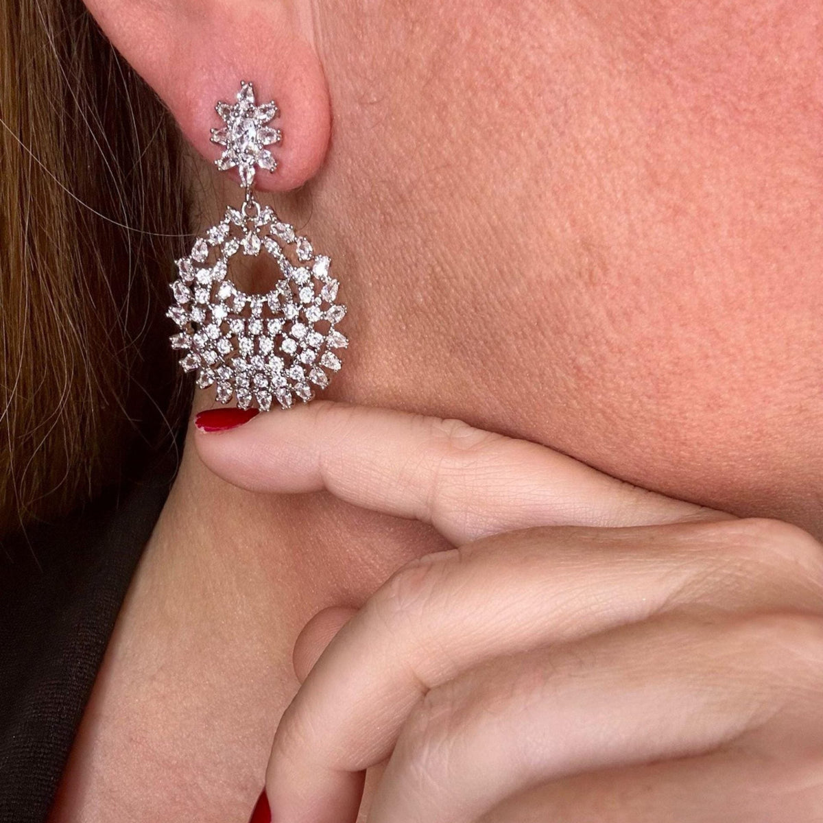Jakris elegant silver-tone crystal drop earrings featuring a floral stud and a circular filigree pendant design
