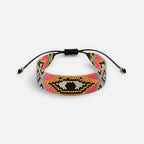 Jakris woven bead bracelet featuring a colorful evil eye pattern with pink, gold, and black glass beads