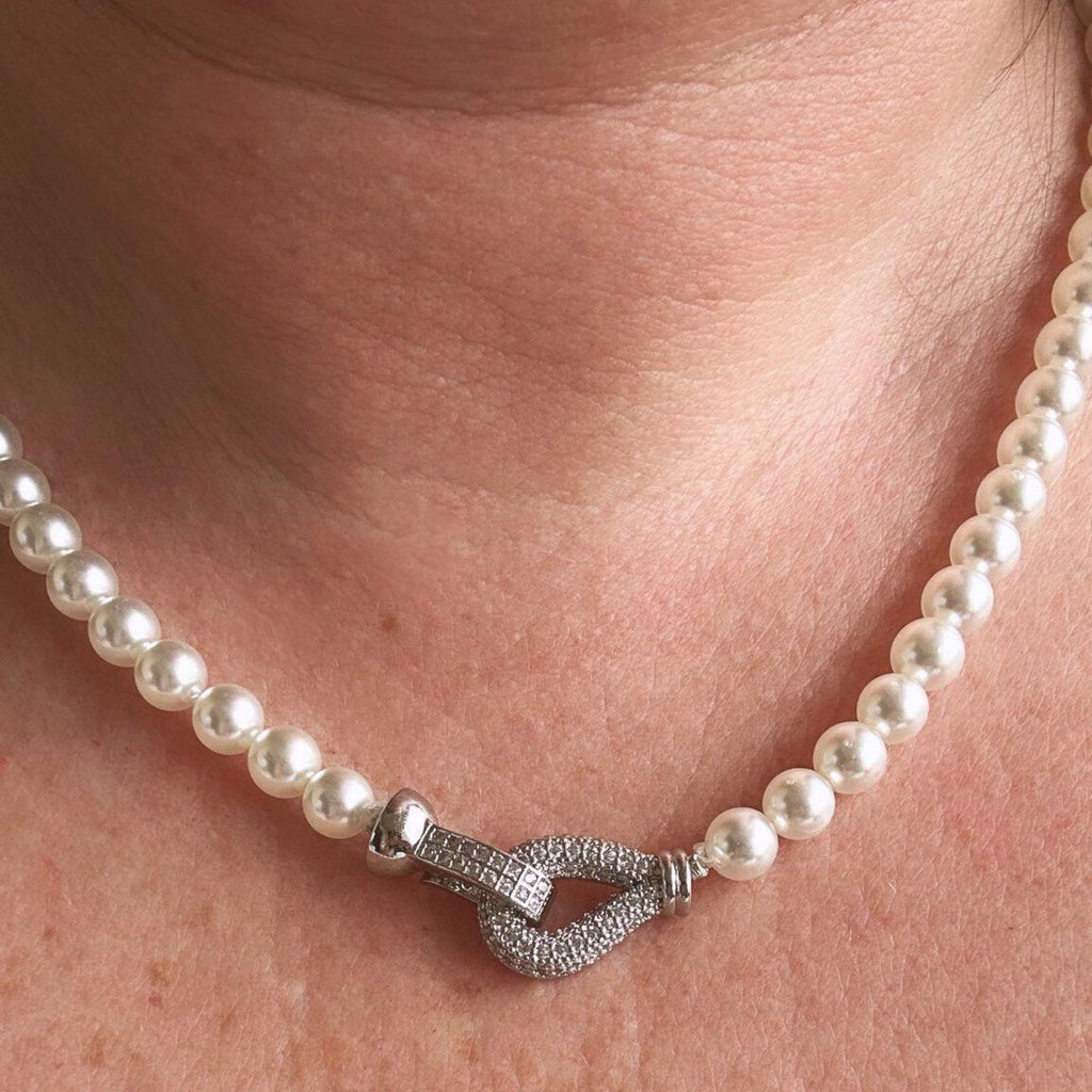 Jakris freshwater pearl choker necklace featuring a sparkling zircon-encrusted clasp worn around the neck