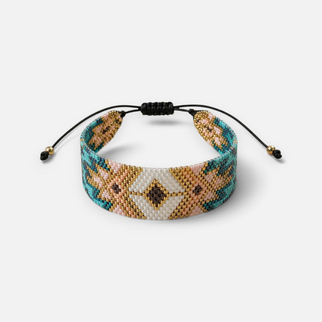 Jakris woven bead bracelet featuring a geometric pattern in turquoise, gold, pink, and white with adjustable cord.