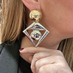 Jakris large geometric statement earrings featuring a gold sphere top and a silver diamond frame with a center sphere
