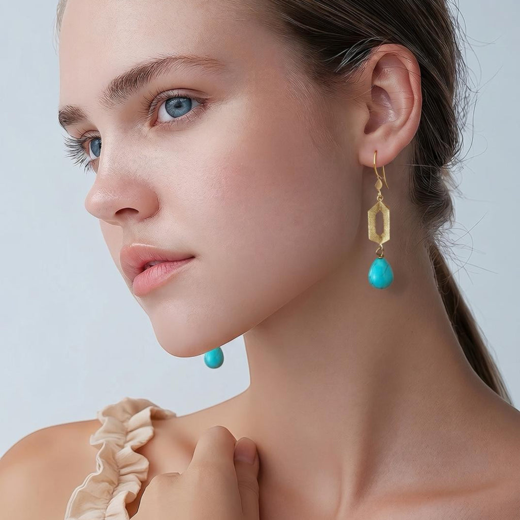 Jakris geometric drop earrings featuring 24k gold-plated bronze and teardrop turquoise stones on a model