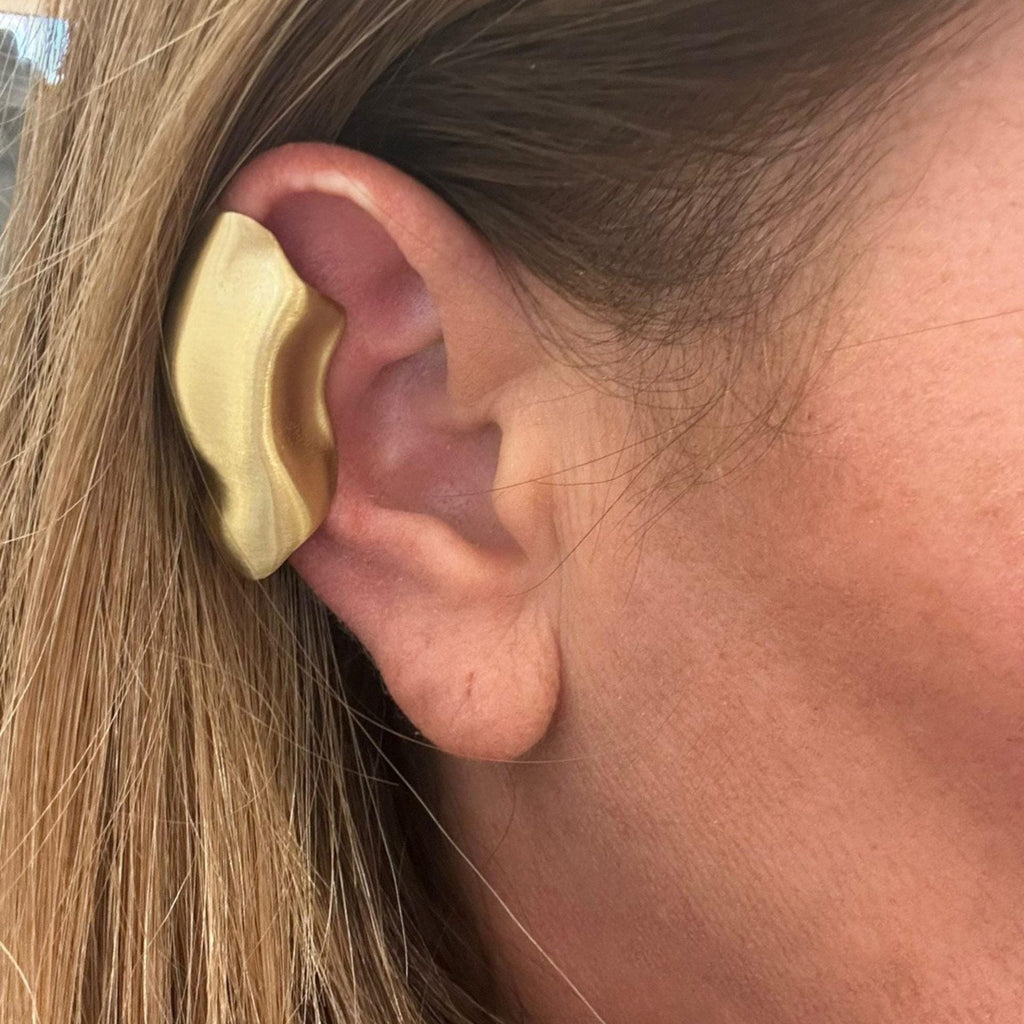 Jakris handmade gold-tone brass sculptural ear cuff worn on the upper cartilage of a woman's ear