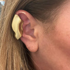 Jakris handmade gold-tone brass sculptural ear cuff worn on the upper cartilage of a woman's ear