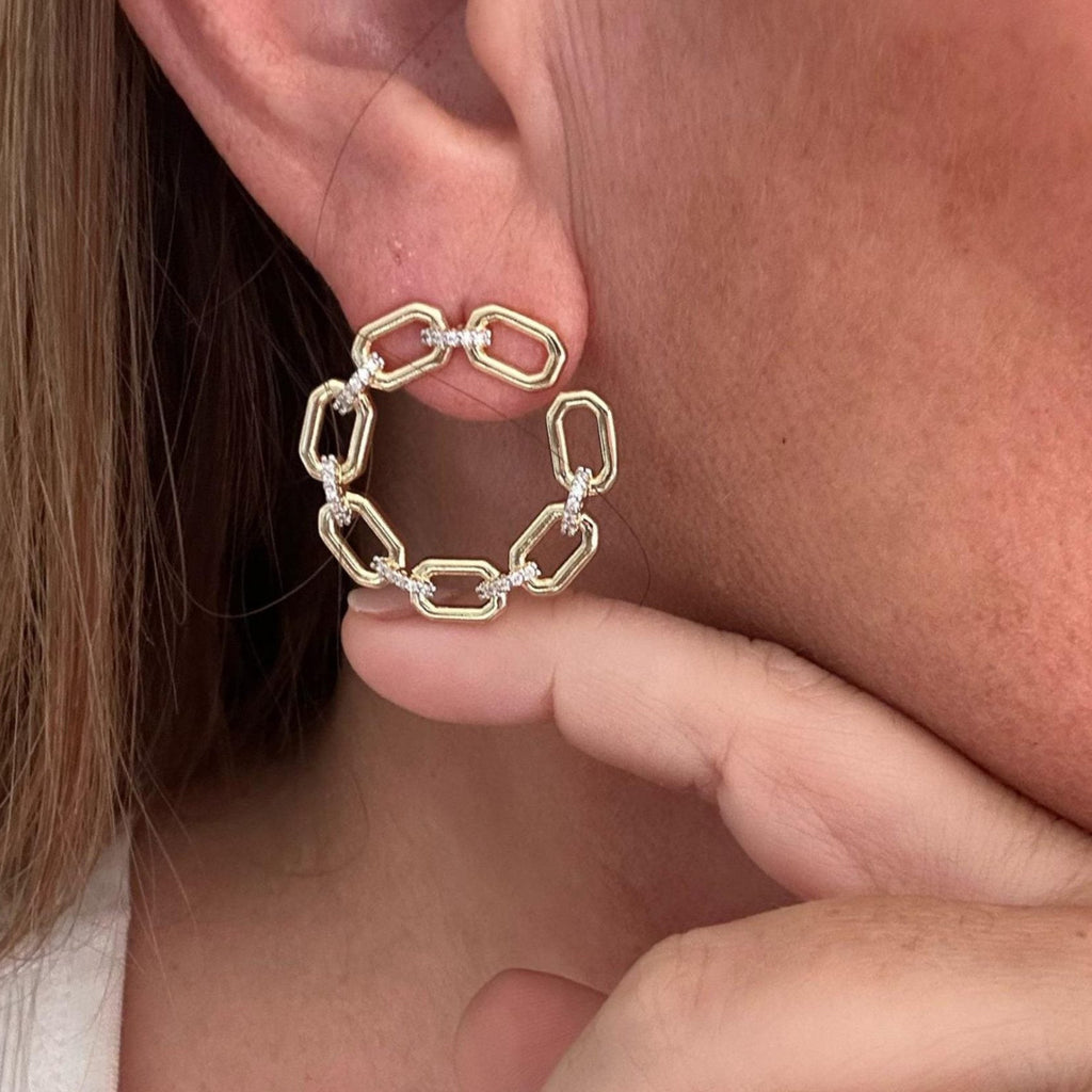 Jakris gold hoop earrings featuring a circular chain link design with small sparkling stone accents on the ear