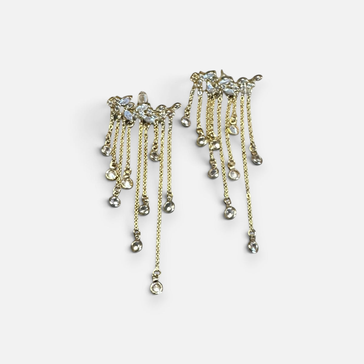 Jakris gold-tone long dangle earrings featuring multiple delicate chains with sparkling crystal leaf accents.
