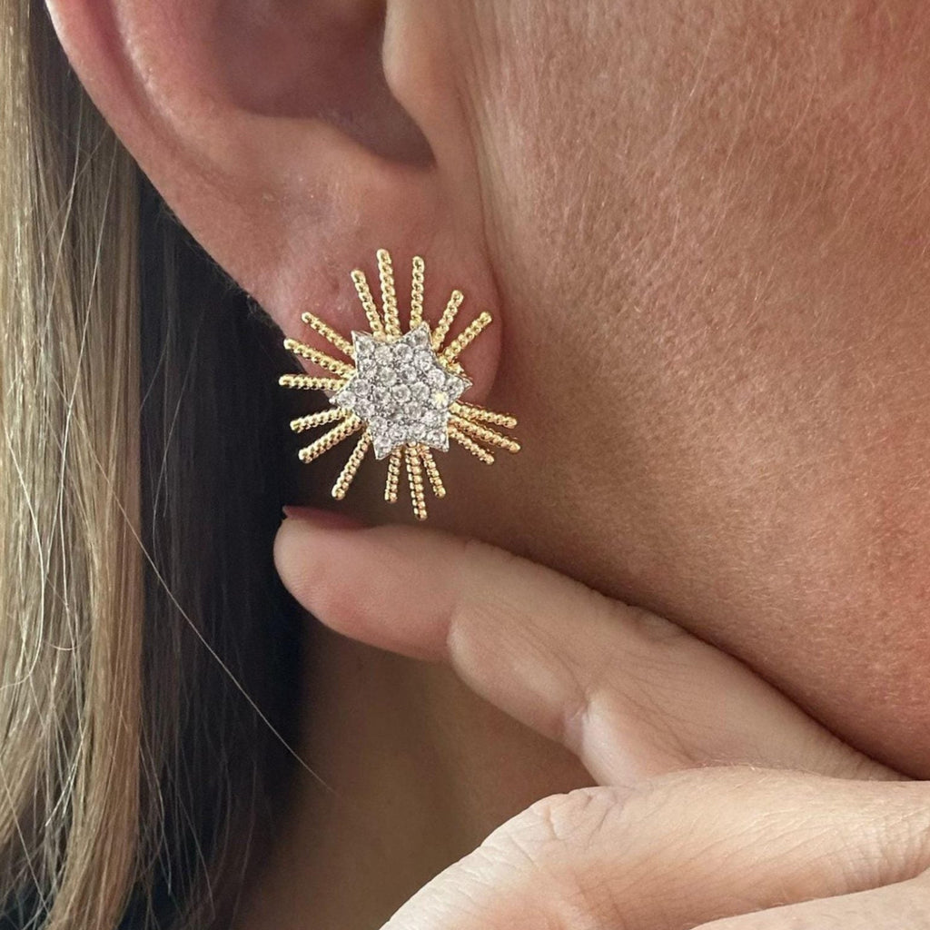 Jakris gold star stud earring with sparkling crystal accents worn on an earlobe