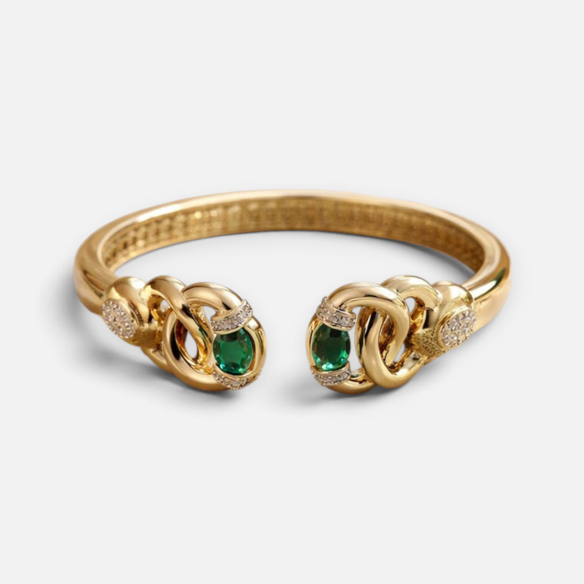 Jakris modern gold cuff bracelet featuring oval green stones and sparkling pavé accents on a polished link design.