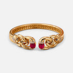 Jakris modern gold cuff bracelet featuring oval red stones and intricate chain-link detailing on a white background.