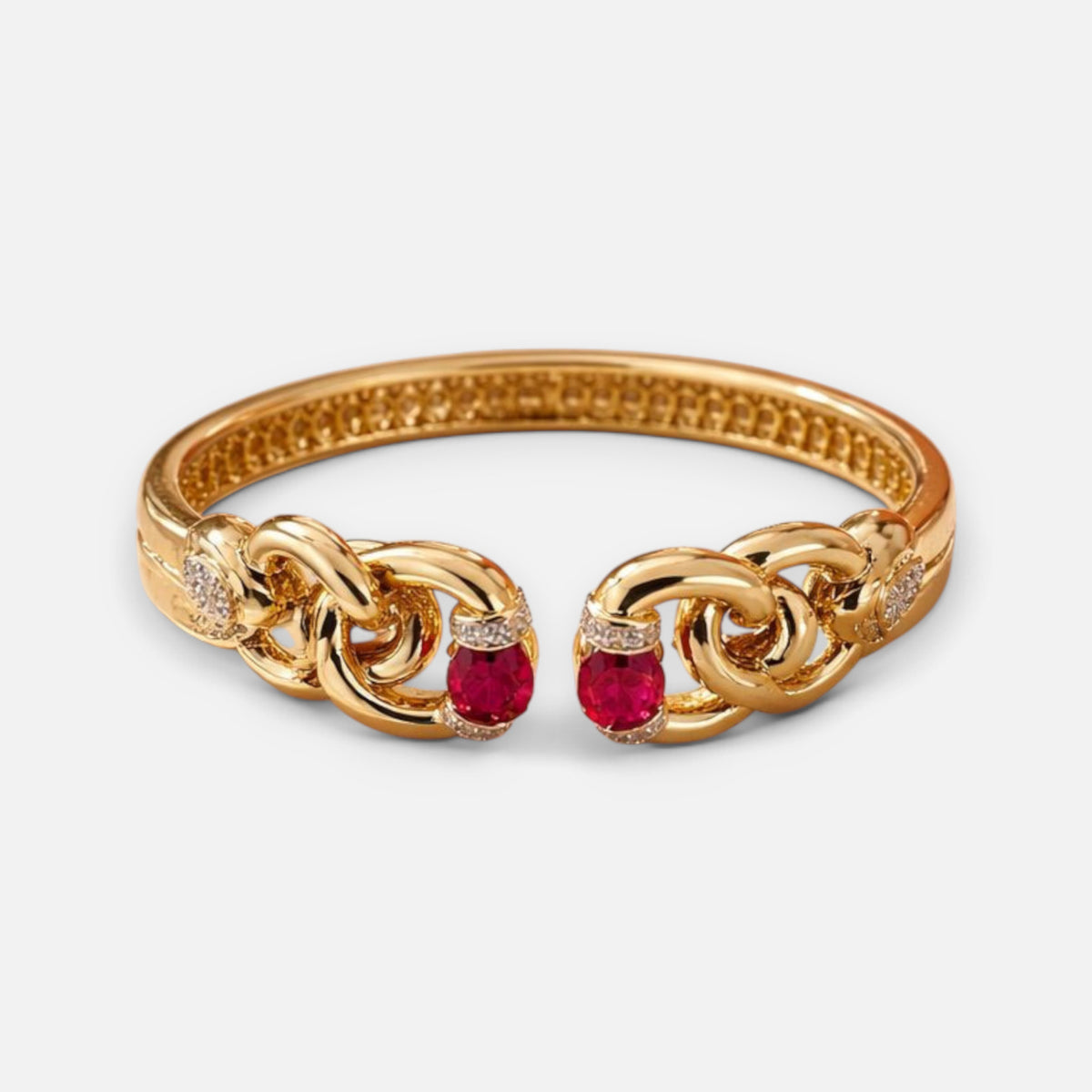 Jakris modern gold cuff bracelet featuring oval red stones and intricate chain-link detailing on a white background.