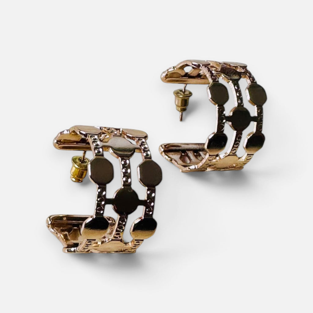Jakris gold-plated hoop earrings featuring a thick dotted cutout design on a white background.