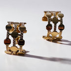 Jakris gold-plated hoop earrings featuring a thick dotted geometric pattern on a white background