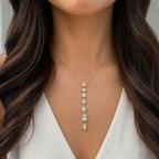 Jakris gold chain necklace featuring a vertical drop of assorted cut clear stones worn on a woman