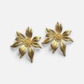 Jakris gold-plated flower-shaped stud earrings with textured centers on a white background